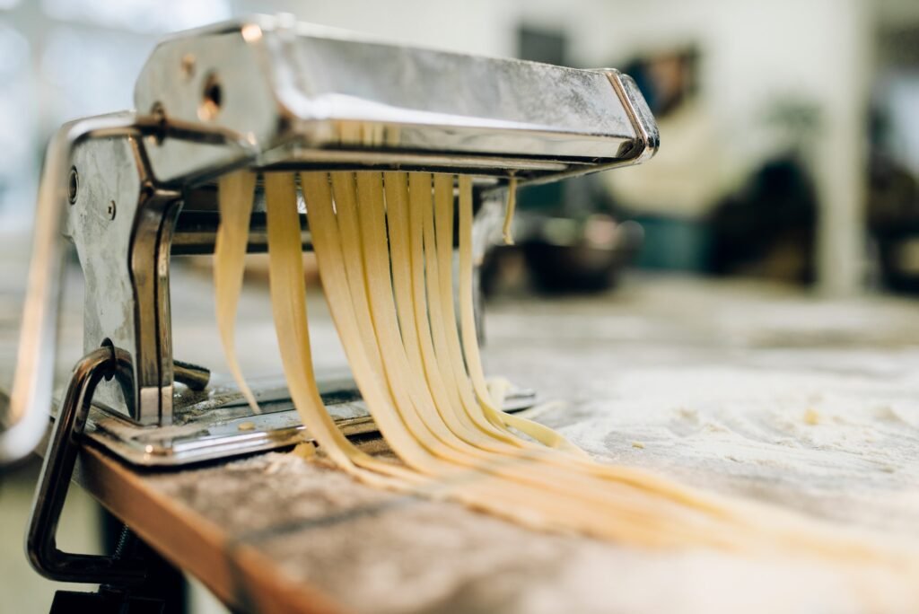 Pasta machine with dough closeup, nobody
